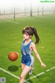 A girl in a blue and white uniform holding a basketball.