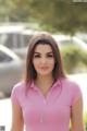 A woman in a pink shirt is posing for a picture.