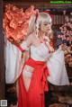 A woman in a red and white kimono posing for a picture.