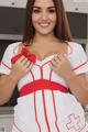 A woman in a white and red nurse outfit posing for the camera.