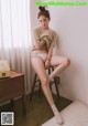 A woman sitting on a stool in a room.